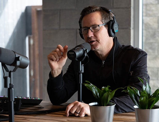 Man sitting at table recording podcast